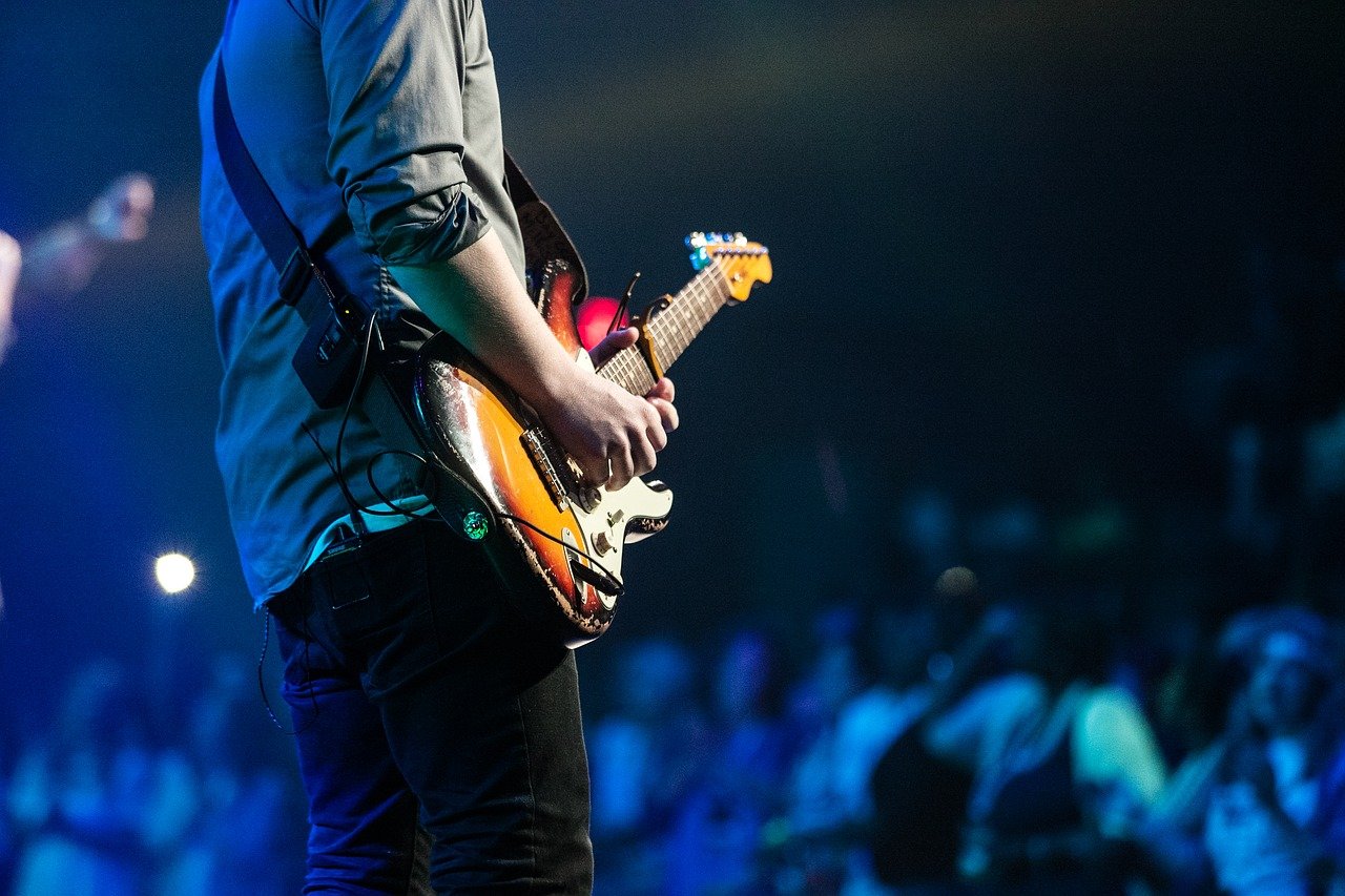 Men is playing a guitar on stage